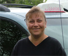 Mrs. posing with her van in the background.